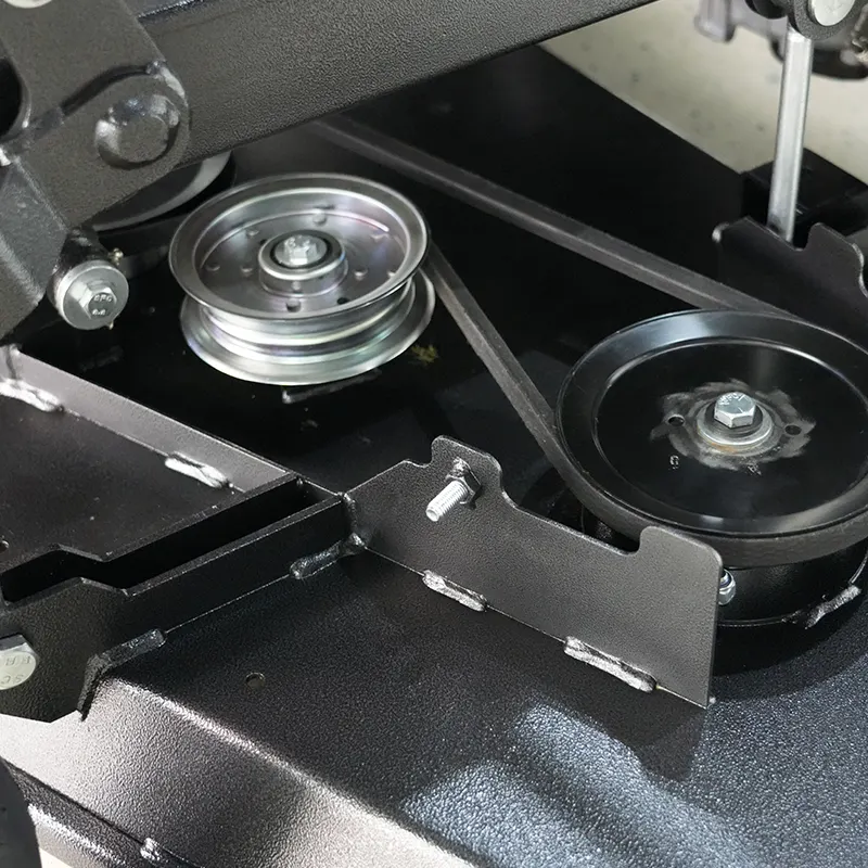 Two black metal pulleys and a silver pulley on a machine frame with a taut belt running between them.